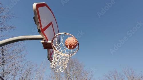 Wallpaper Mural A Basketball Flies High And Scores In The Hoop On An Outdoor Court In A Park. This Scene Captures The Thrill Of Scoring In A Basketball Game, Ideal For Sports Training Or Competition. Torontodigital.ca