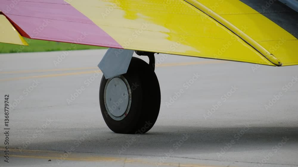 A propeller plane ridding on the taking off lane at the small airport. Green, bright sunny summer day. 