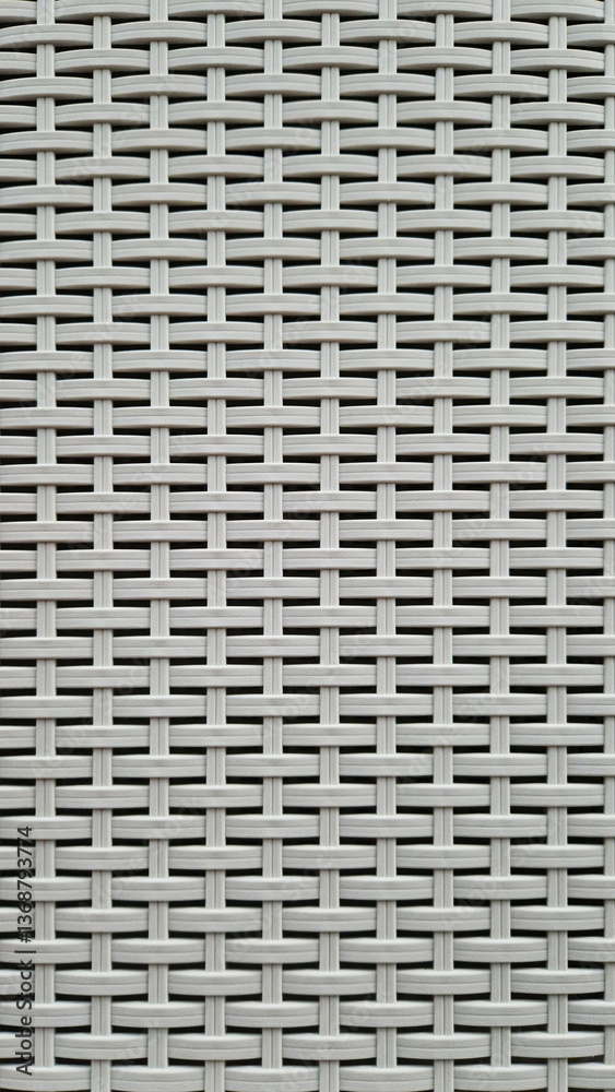Close-up of woven plastic surface of laundry basket. Close-up of synthetic plastic pattern. Close-up of woven surfaces of plastic household baskets. Texture. Plastic rattan with symmetrical pattern Close-up of woven plastic surface of laundry basket. Close-up of synthetic plastic pattern. Close-up of woven surfaces of plastic household baskets. Texture. Plastic rattan with symmetrical pattern