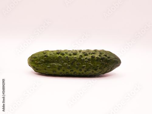 Green cucumber, lying horizontally on a white background, side view, close-up