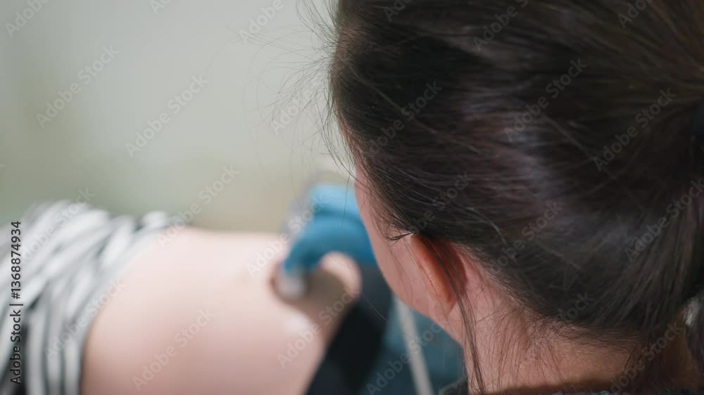 aerial view of clinical laboratory specialist scanning patient belly while attentively observing monitor display for accurate imaging results during real-time diagnostic ultrasound session aerial view of clinical laboratory specialist scanning patient belly while attentively observing monitor display for accurate imaging results during real-time diagnostic ultrasound session