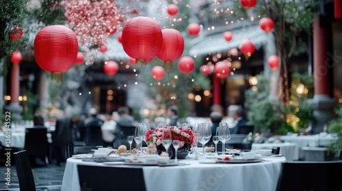 Elegant outdoor dining experience, festive atmosphere.  Red lanterns and floral arrangements enhance the ambiance of a lavish outdoor banquet