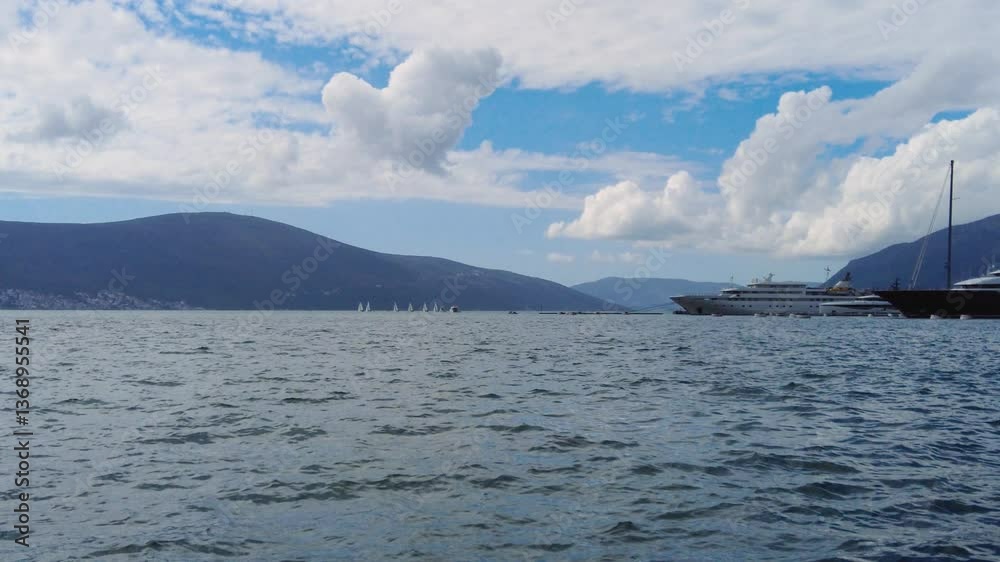 View of the sea from the pier where sailing ships can be seen in the distance View of the sea from the pier where sailing ships can be seen in the distance