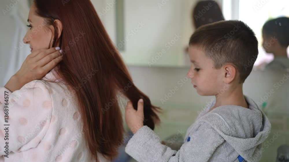 A truly heartwarming moment unfolds as a child lovingly brushes a womans long hair while in the bathroom A truly heartwarming moment unfolds as a child lovingly brushes a womans long hair while in the bathroom