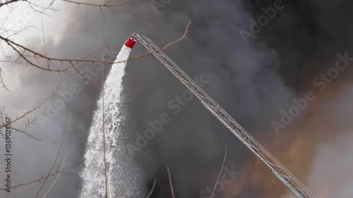 Firefighters are putting out a large fire, foam fire hose, directs a powerful stream to extinguish the fire. Tense fire fighting, professionalism 