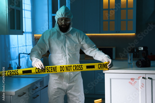 Forensic expert blocking way to crime scene with yellow tape indoors photo
