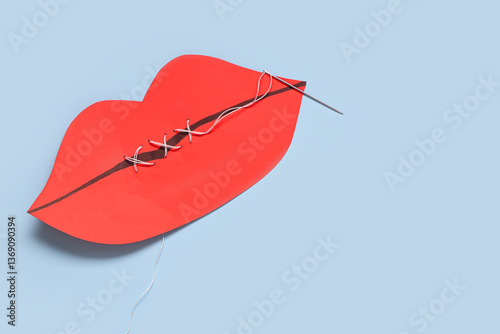 Sewn paper lips on blue background. Domestic violence concept