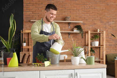Young male gardener waterin...