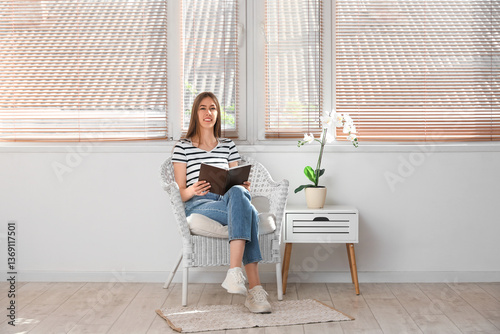 Young woman reading book wh...