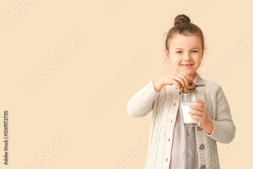 Little girl dipping cookie ...