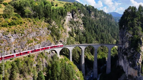Train passing over the iconic Landwasser Viaduct before disappearing into a tunnel