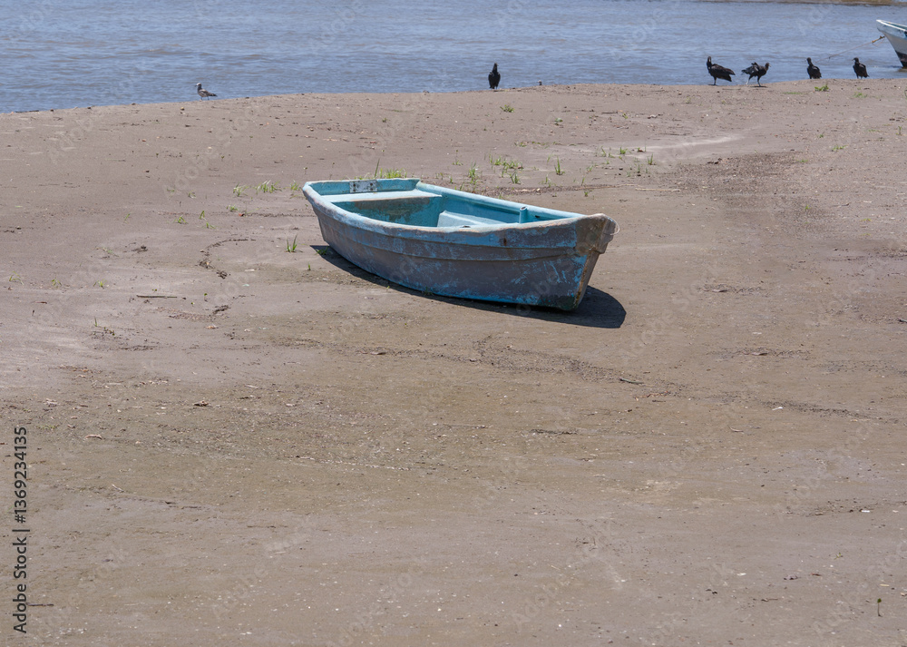 Lancha varada en la arena con fondo del mar y aves Lancha varada en la arena con fondo del mar y aves