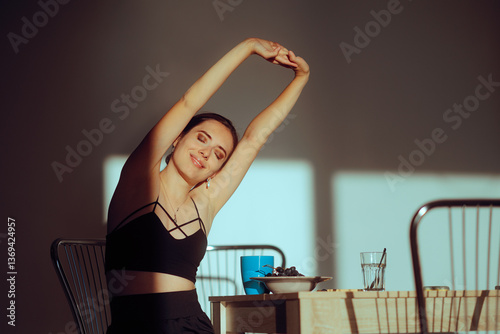 Smiling Woman Stretching her Arms After Waking up in the Morning. Athletic lady stretching her limbs  before having breakfast 
