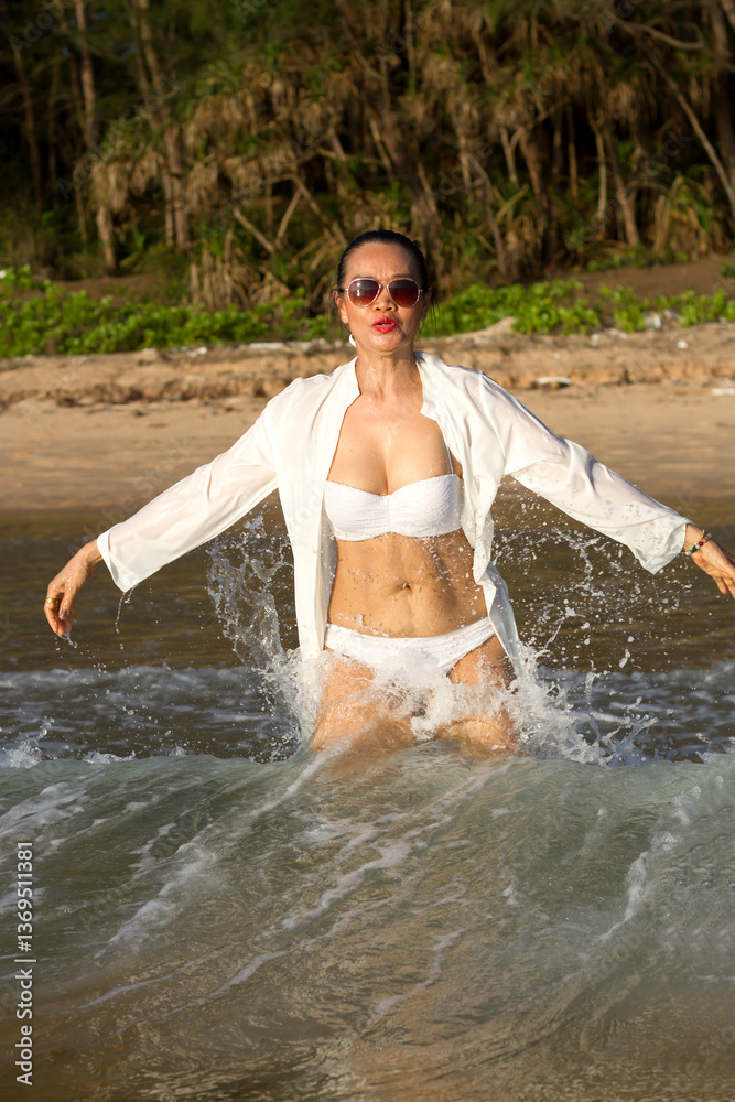 Obraz premium Woman with white bikini play water at beach