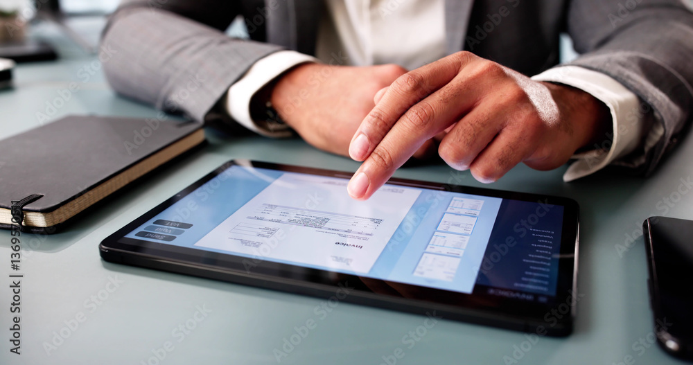 Young accountant calculating expenses, preparing electronic invoice
