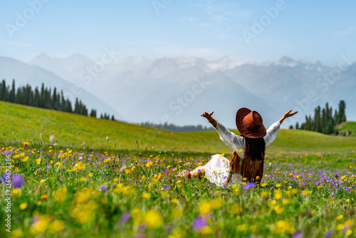 Young woman traveler relaxing and enjoying beautiful Scenery landscape with colorful flowers in Kalajun grassland of Xinjiang in summer