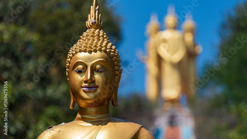 Golden Buddha statue with multi-armed deity in background, northern Thailand