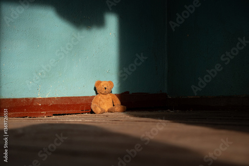 A brown soft teddy bear lies abandoned on the floor in an old abandoned house in Ukraine
