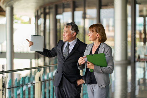 Two senior business people walking tour office before start the job on building corridor.