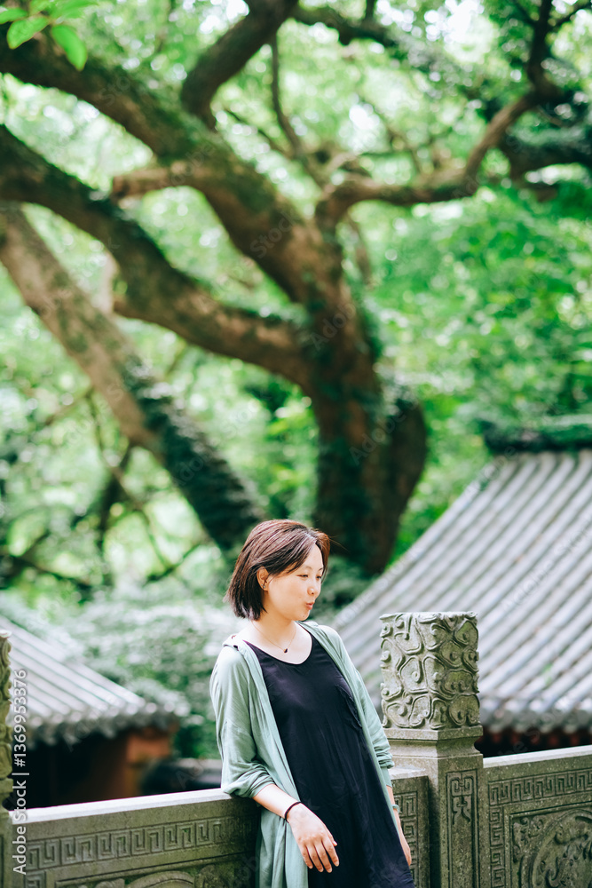 Fototapeta premium A Chinese woman traveling at a temple on Putuo Mountain in Ningbo, Zhejiang, China, during summer season