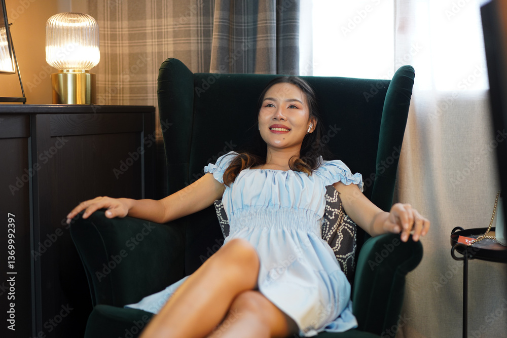 Obraz premium asian woman relaxing on green armchair at home