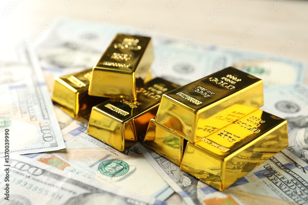 Shiny gold bars and dollar banknotes on table, closeup Shiny gold bars and dollar banknotes on table, closeup