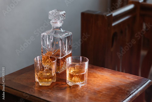 Bild auf Leinwand Whisky in geschliffener Glaskaraffe mit zwei Gläsern auf Holztisch