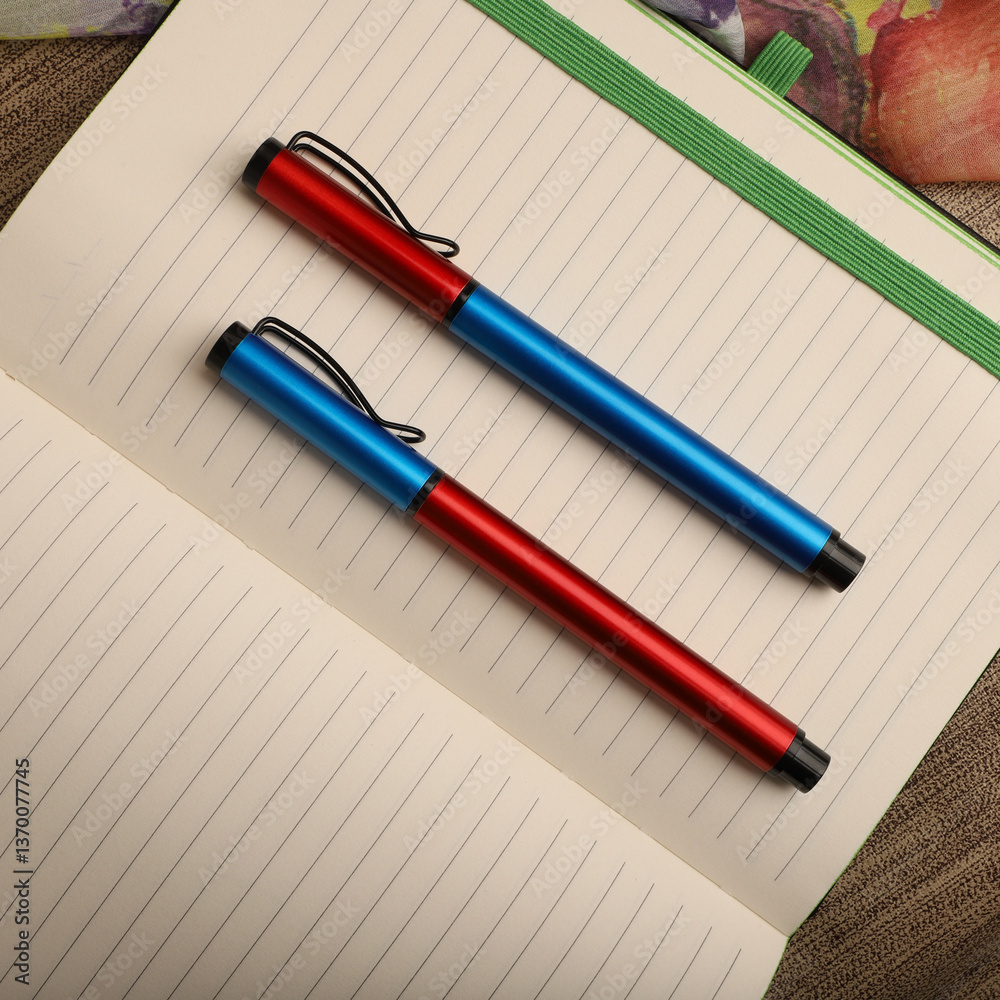 Elegant Pen Standing on Open Notebook with Vivid Decorative Backdrop, concept idea photo. Study desk image, top view. Elegant Pen Standing on Open Notebook with Vivid Decorative Backdrop, concept idea photo. Study desk image, top view.
