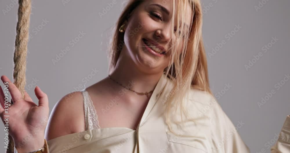 A joyful woman enjoys swinging, illuminated by soft and beautiful natural light A joyful woman enjoys swinging, illuminated by soft and beautiful natural light
