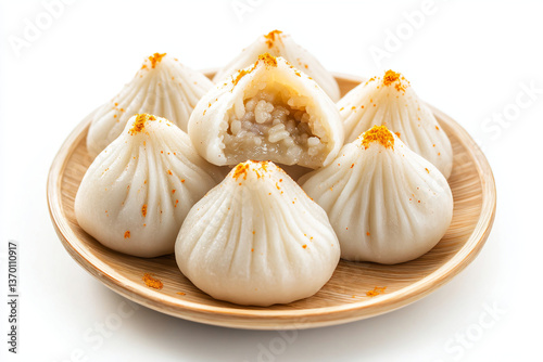 a plate of steamed dumplings with a bite taken out of one