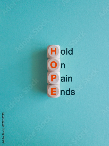 Obraz na płótnie HOPE, hold on, pain ends symbol. Wooden cubes with words 'HOPE, hold on, pain ends. Beautiful blue background. Business, motivational and HOPE, hold on, pain ends concept. w salonie