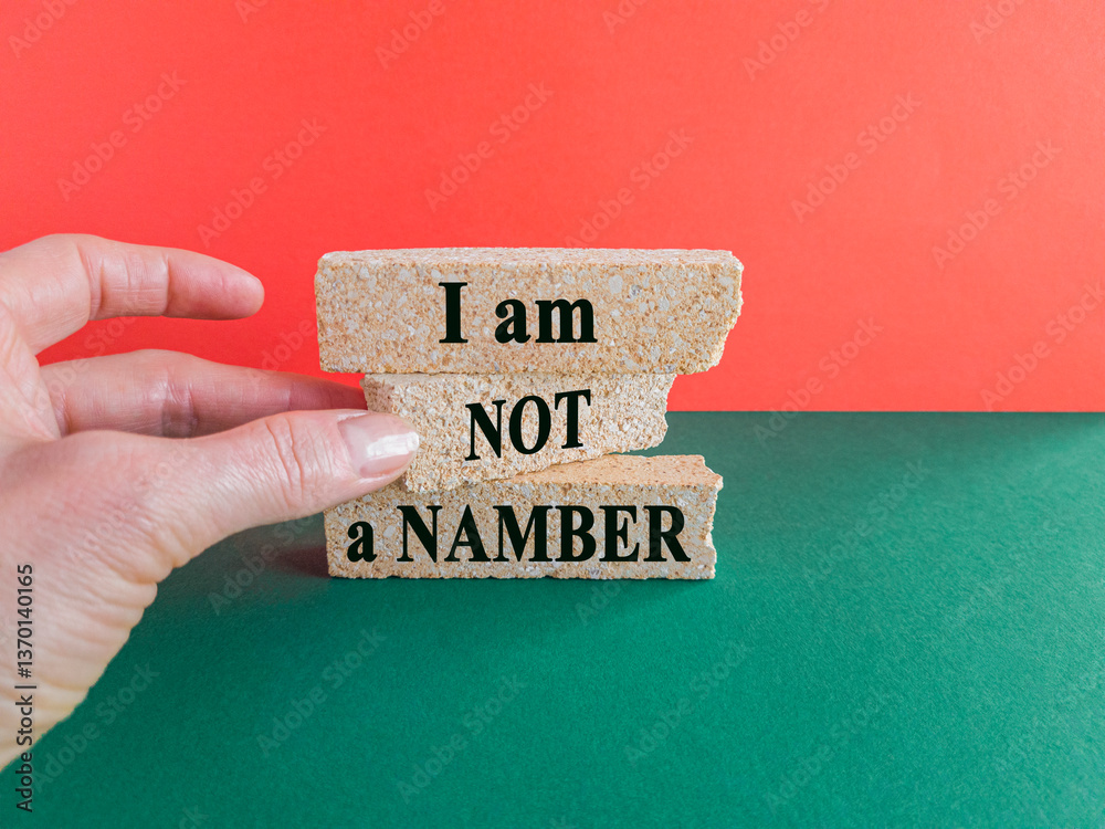 The expression I am not a number written on beautiful brick blocks. Beautiful red background, green table. Businessman hand. Business your opinion matters concept.