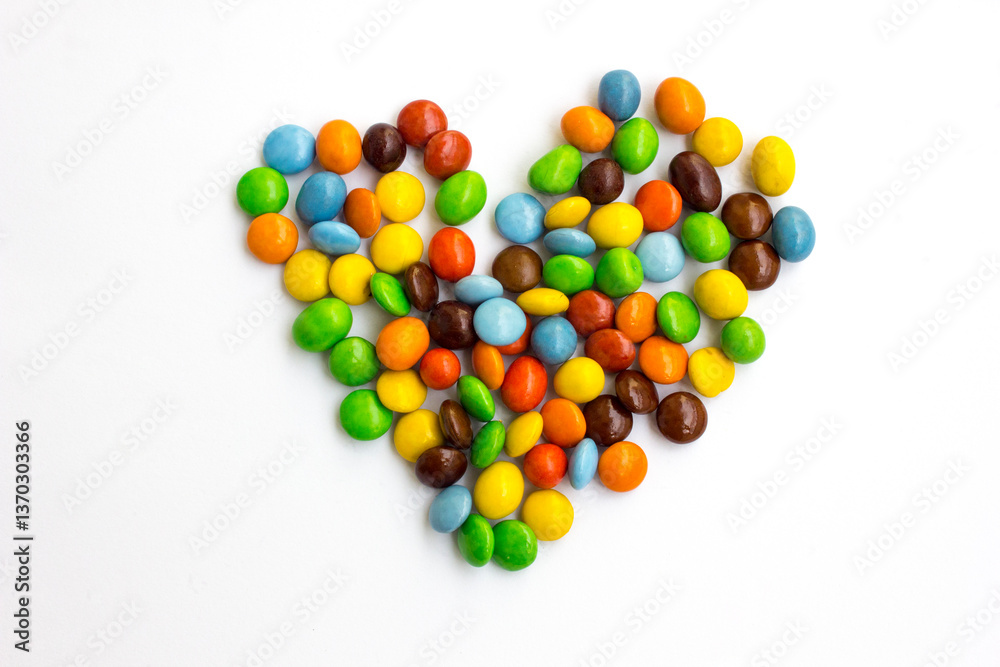 A pile of colorful chocolate candies arranged in the shape of a heart. A pile of colorful chocolate candies arranged in the shape of a heart.