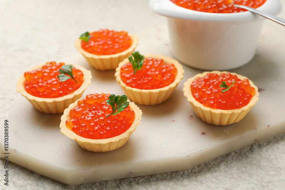 Tartlets with red caviar and parsley on beige table, closeup Tartlets with red caviar and parsley on beige table, closeup