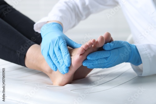 Obraz na płótnie Doctor examining patient's foot in hospital, closeup