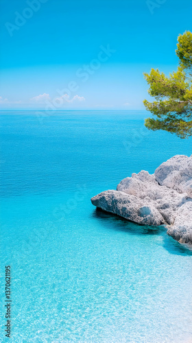 Tranquil turquoise ocean meets rocky shore under a vibrant blue sky