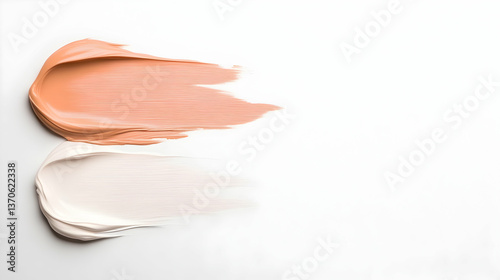 Two cosmetic cream swatches, peach and white, smeared on white background