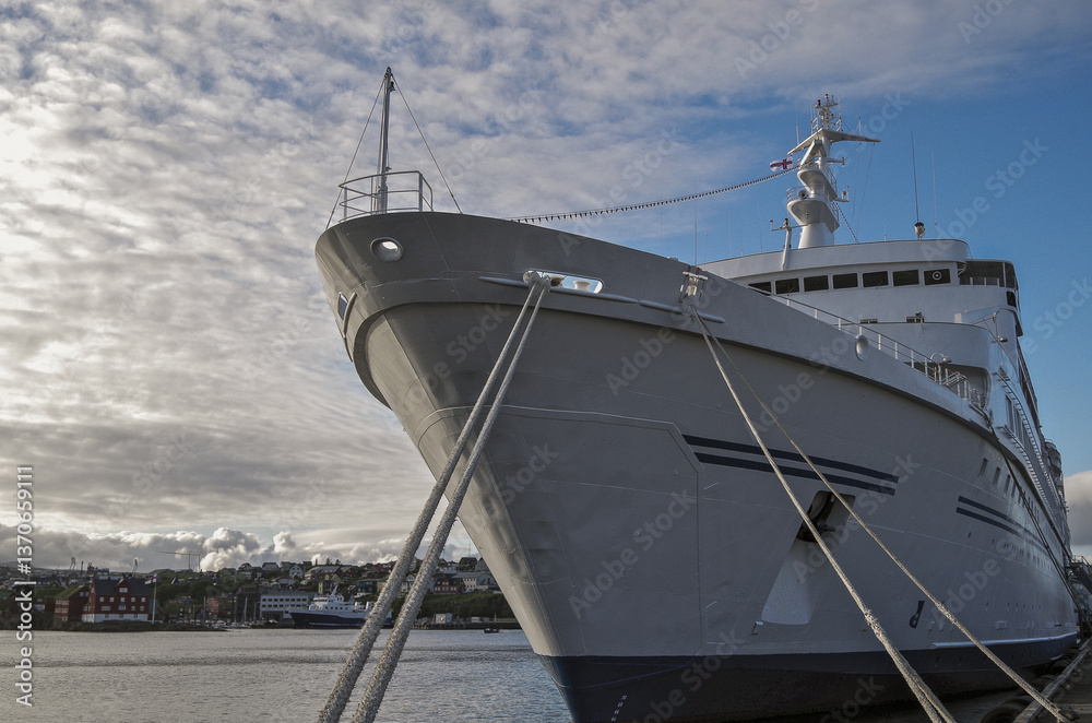 Classic expedition cruiseship cruise ship liner Delphin docked at terminal in Thorshavn Thorshaven, Faroe Islands with city skyline fjord landscape in background during Arctic Circle summer cruising