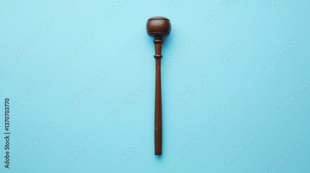 A wooden gavel is centered on a light blue backdrop A wooden gavel is centered on a light blue backdrop