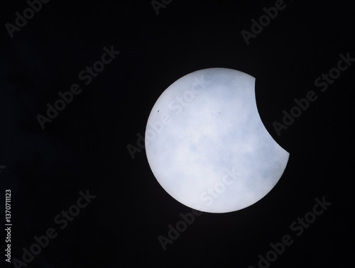 Partial solar eclipse on 29.03.2025 in Germany, northern Germany, near Bremen, veil clouds can be seen in the foreground.