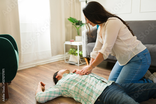 Obraz na płótnie Medical professional performing cpr on unresponsive male patient during cardiac emergency in residential setting w salonie
