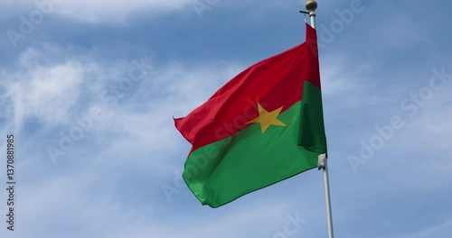 Flag of Burkina Faso. National Flag of Burkina Faso fluttering in the wind. Close-up. Great for news. Flag of Burkina Faso against blue sky. 4K video.