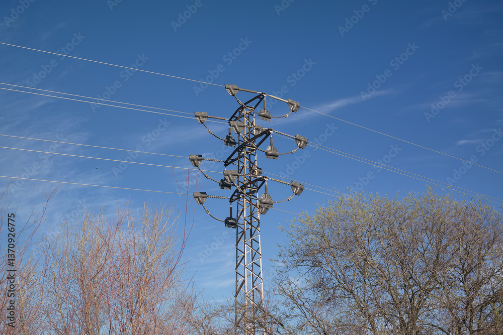 Power lines stretch across the landscape under a clear blue sky
