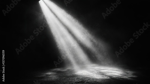 A single spotlight illuminates a dark space, creating dramatic shadows. The intense beam contrasts against the surrounding darkness, emphasizing the deep emptiness of the environment. 