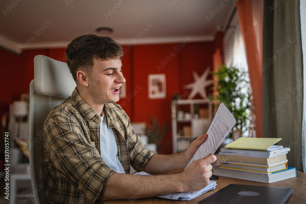 Fototapeta premium young man student study for exam from notes and books at home