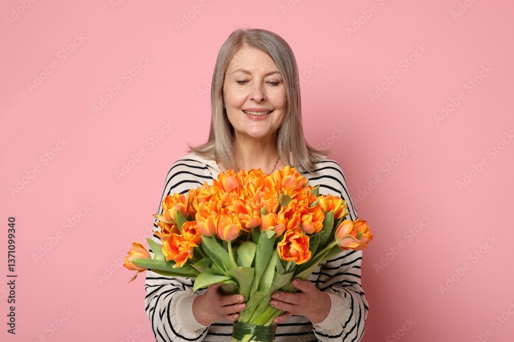 Smiling woman with bouquet of tulips on pink background Smiling woman with bouquet of tulips on pink background