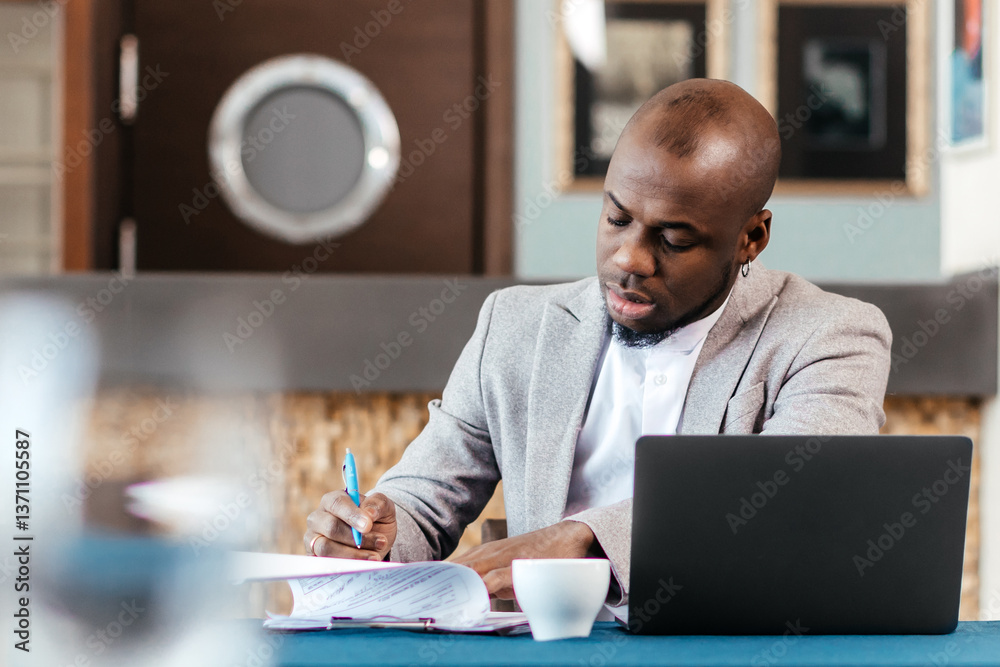 Obraz premium Head shot serious puzzled African American businessman looking at laptop screen sitting in office. Executive managing thinking received bad news keeping fist at chin waiting hoping positive result.