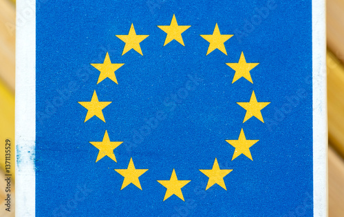 Macro closeup of European Union flag printed on textured paper blue background with twelve yellow stars in a circle. Europe, official EU emblem printed on a EU-made product packaging concept, nobody