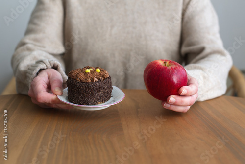 Woman holding cake and apple healthy vs unhealthy food concept