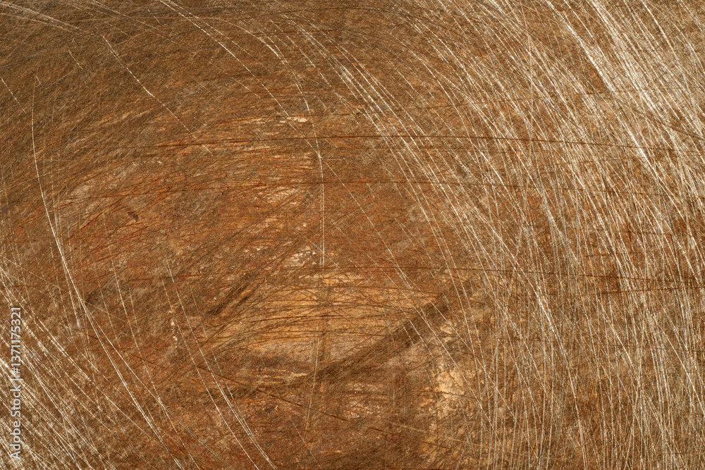 Naklejka premium Weathered steel surface displaying deep scratches, revealing aged texture with rich, warm brown patina highlighting surface imperfections